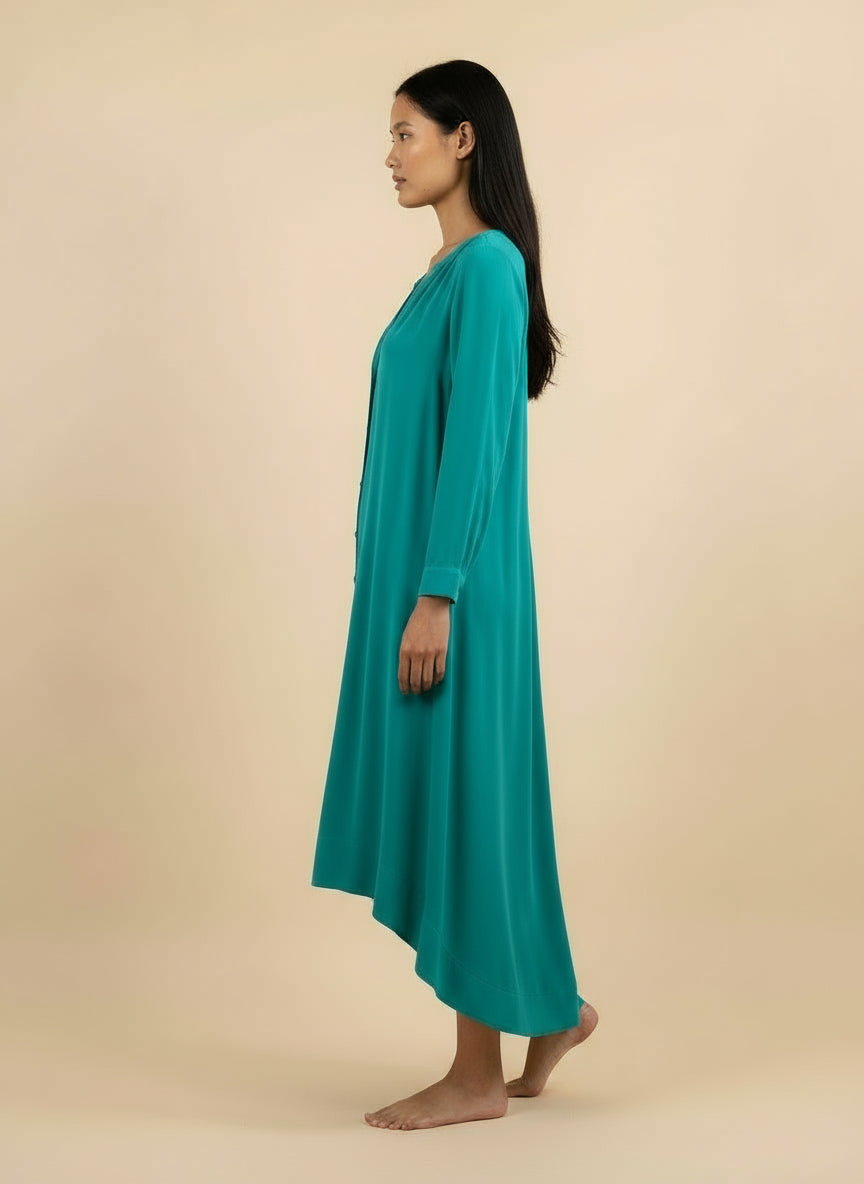 Woman wearing a teal dress against a beige background