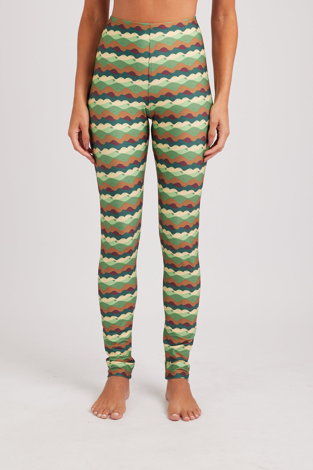 Person wearing colorful zigzag patterned leggings on a plain background