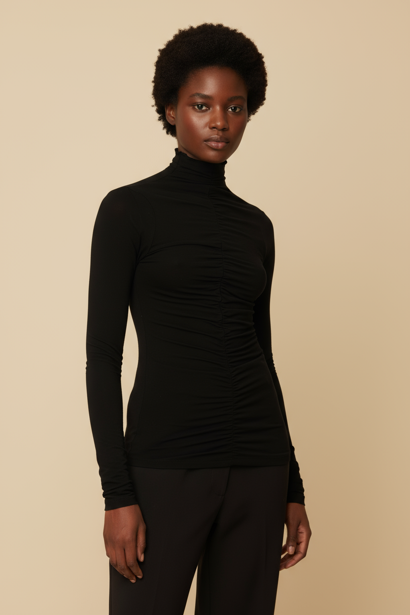 Woman wearing a black turtleneck and pants against a white background