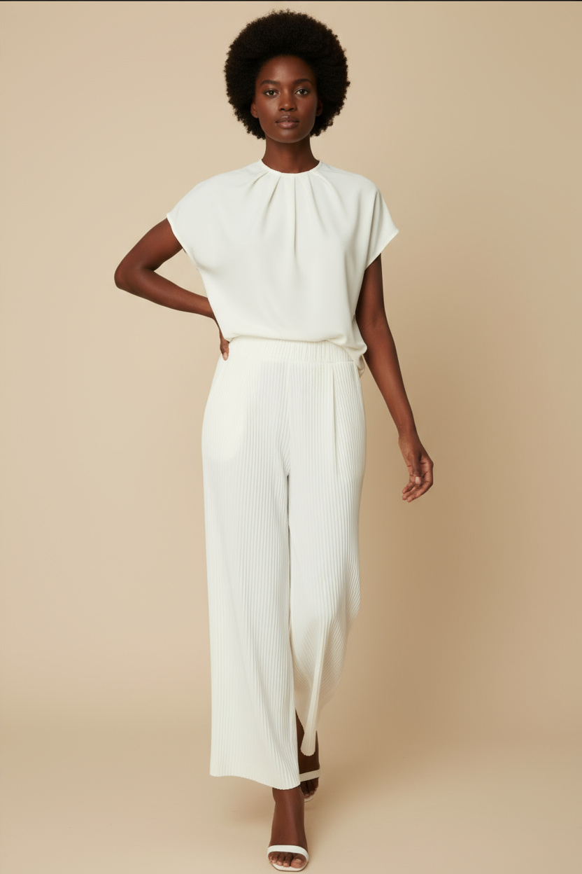 Woman wearing a white outfit against a plain background