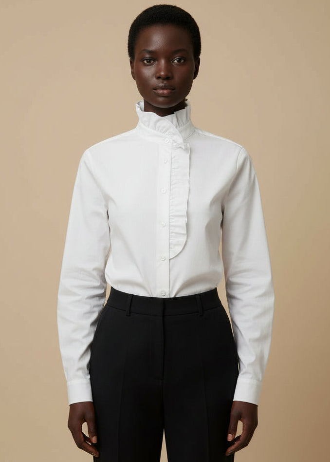 White blouse with a high collar worn by a person against a neutral background